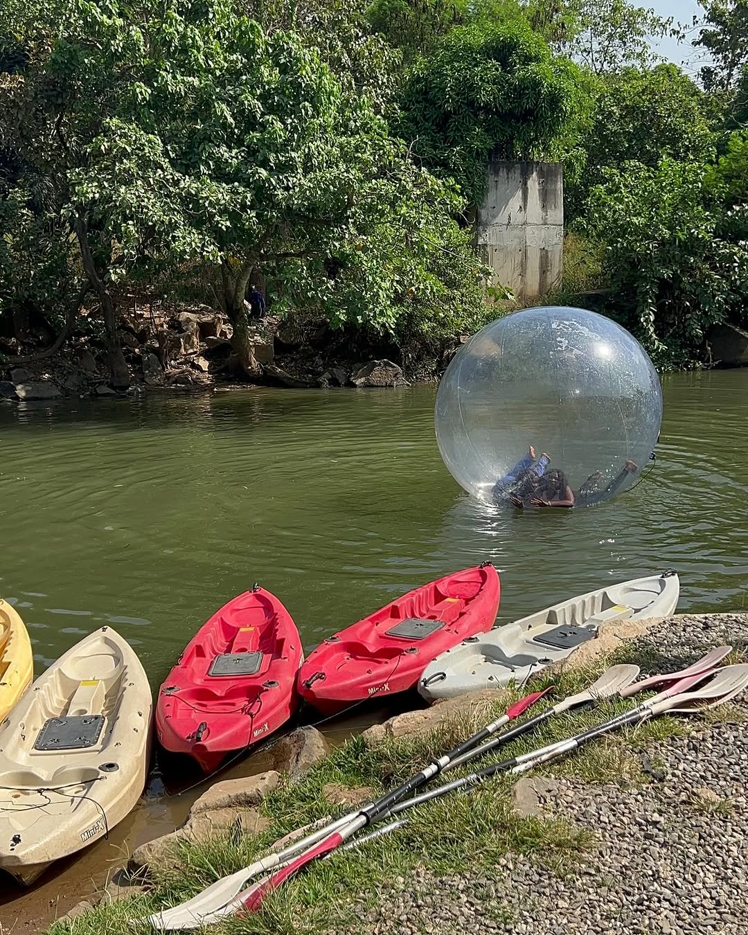A line up of boats and a tourist floating in a balloon at Amazon Kayak, Abuja.