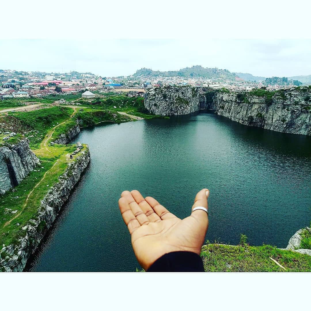 A hand pointing towards Mpape Crushed Rock in Abuja.
