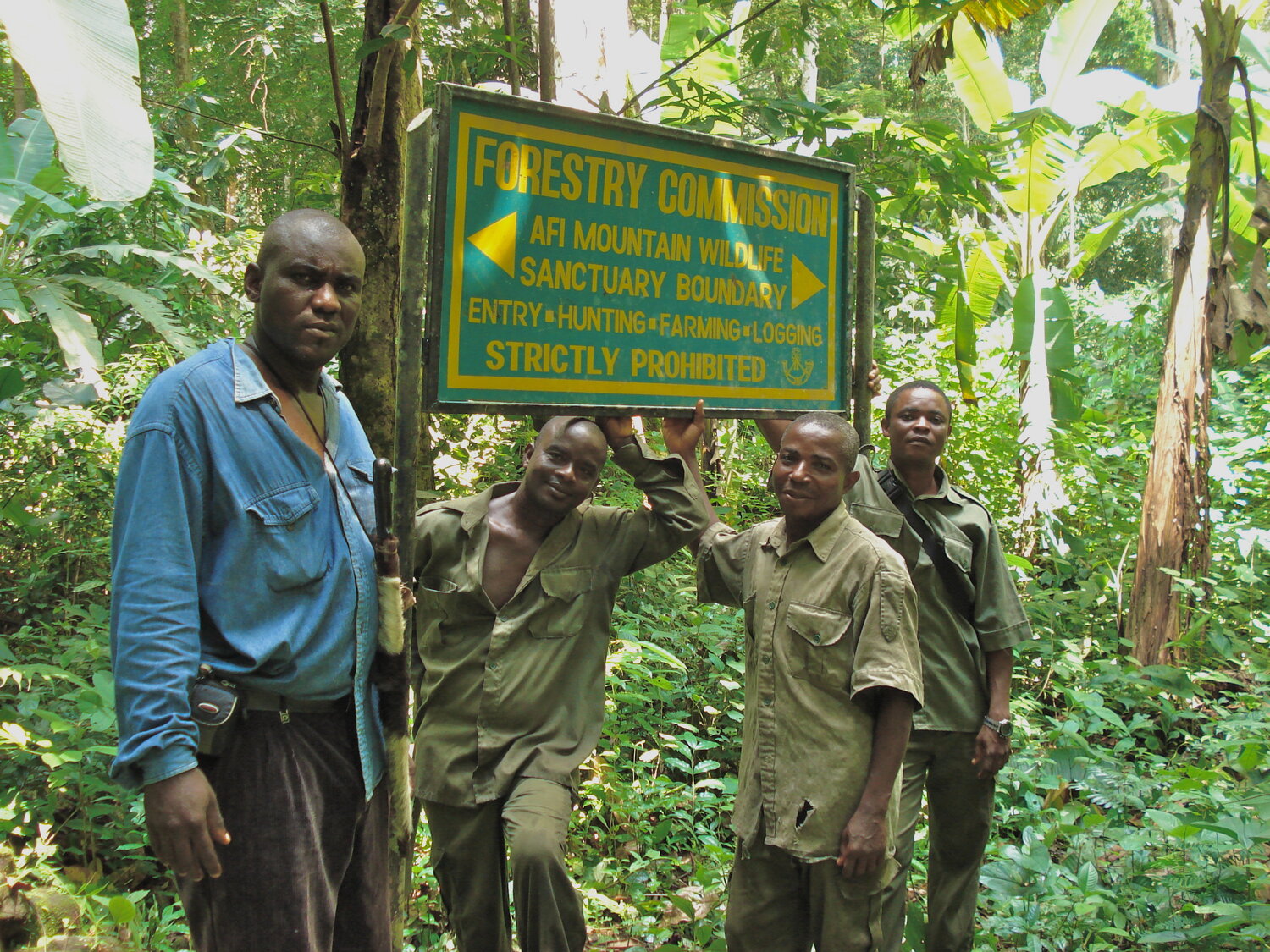 Locals standing by a signpost at the Afi Mountain Mountain Wildlife Sanctuary.